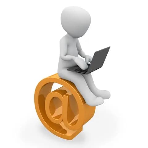 man sitting on at sign while using a lap